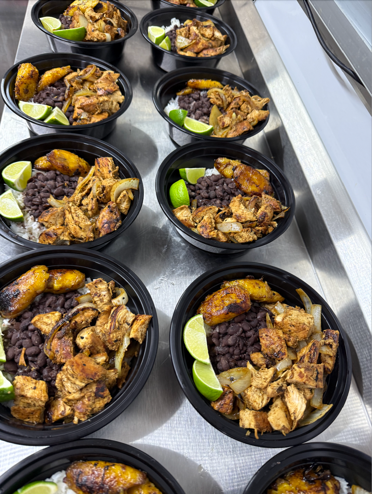 Cuban catering bowls with mojo chicken, black beans, rice and sweet plantains from Cuban Cracker Family Kitchen